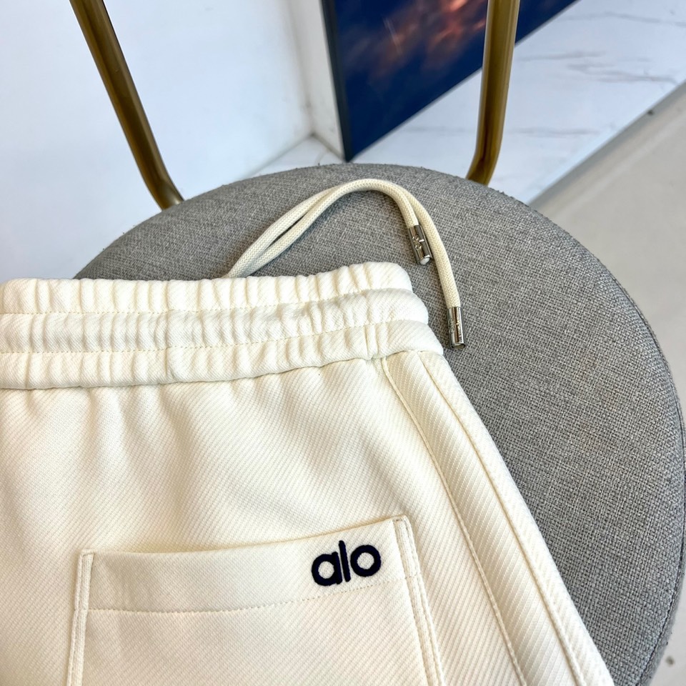 Alo-2025秋冬新品运动裤，款式采用直筒廓形搭配弹性抽绳腰头，裤身两侧饰有线条装饰延伸至裤脚，左腿处