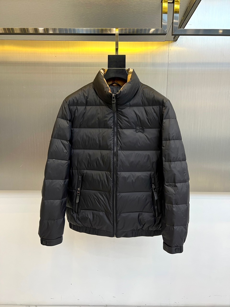 Bur巴宝莉、2025秋冬新品羽绒服，以经典黑色演绎现代英伦风尚。款式采用立领设计，领口内侧饰有品牌标志