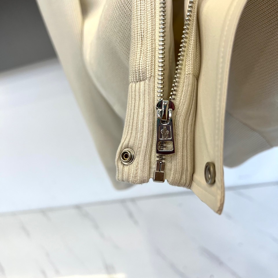 Mon蒙口、2025秋冬新品都市针织拼接羽绒服外套夹克。连帽设计搭配银色纽扣开合系统，左胸贴袋饰有品牌经