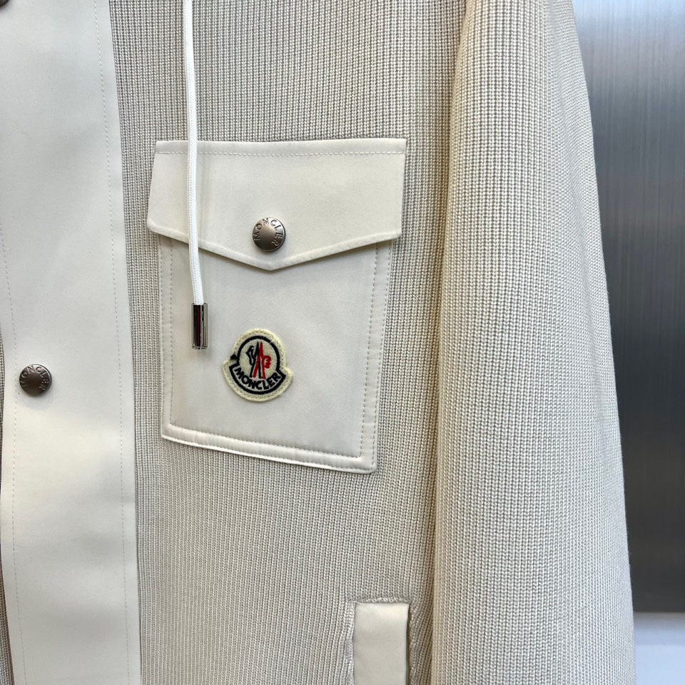 Mon蒙口、2025秋冬新品都市针织拼接羽绒服外套夹克。连帽设计搭配银色纽扣开合系统，左胸贴袋饰有品牌经