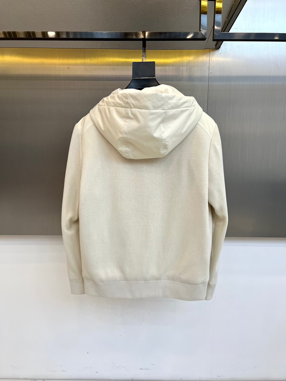 Mon蒙口、2025秋冬新品都市针织拼接羽绒服外套夹克。连帽设计搭配银色纽扣开合系统，左胸贴袋饰有品牌经