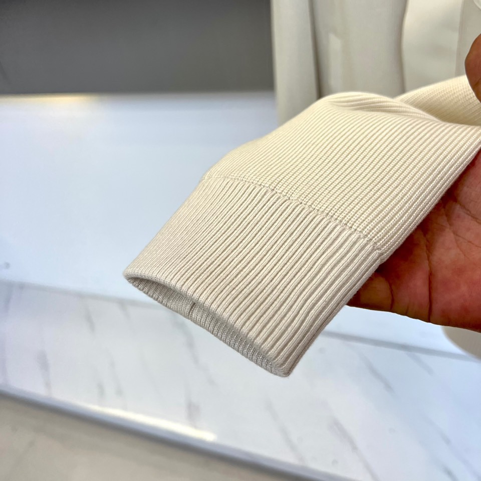 Mon蒙口、2025秋冬新品都市针织拼接羽绒服外套夹克。连帽设计搭配银色纽扣开合系统，左胸贴袋饰有品牌经