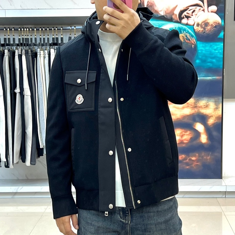 Mon蒙口、2025秋冬新品都市针织拼接羽绒服外套夹克。连帽设计搭配银色纽扣开合系统，左胸贴袋饰有品牌经