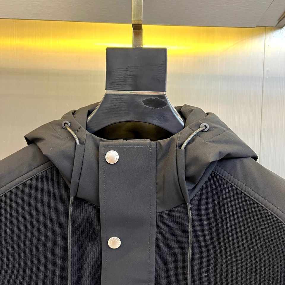 Mon蒙口、2025秋冬新品都市针织拼接羽绒服外套夹克。连帽设计搭配银色纽扣开合系统，左胸贴袋饰有品牌经