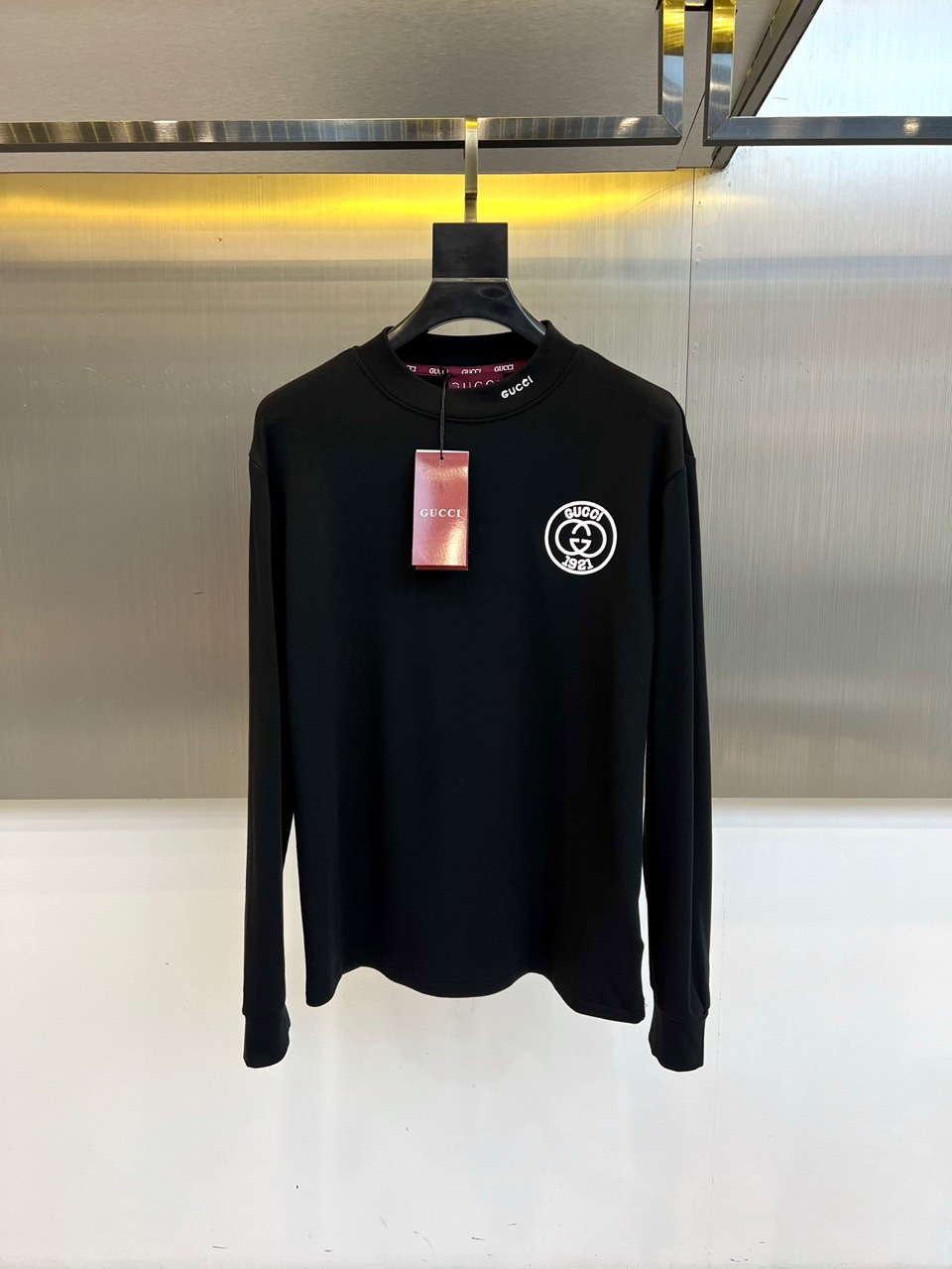 Gucc古驰、2025秋冬新品男士白色长袖上衣，以纯净白色诠释意式奢华美学。衣领处饰有黑色“GUCCI”