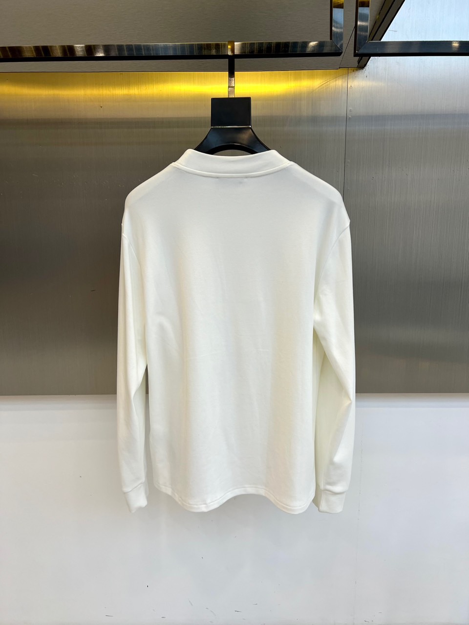 Gucc古驰、2025秋冬新品男士白色长袖上衣，以纯净白色诠释意式奢华美学。衣领处饰有黑色“GUCCI”