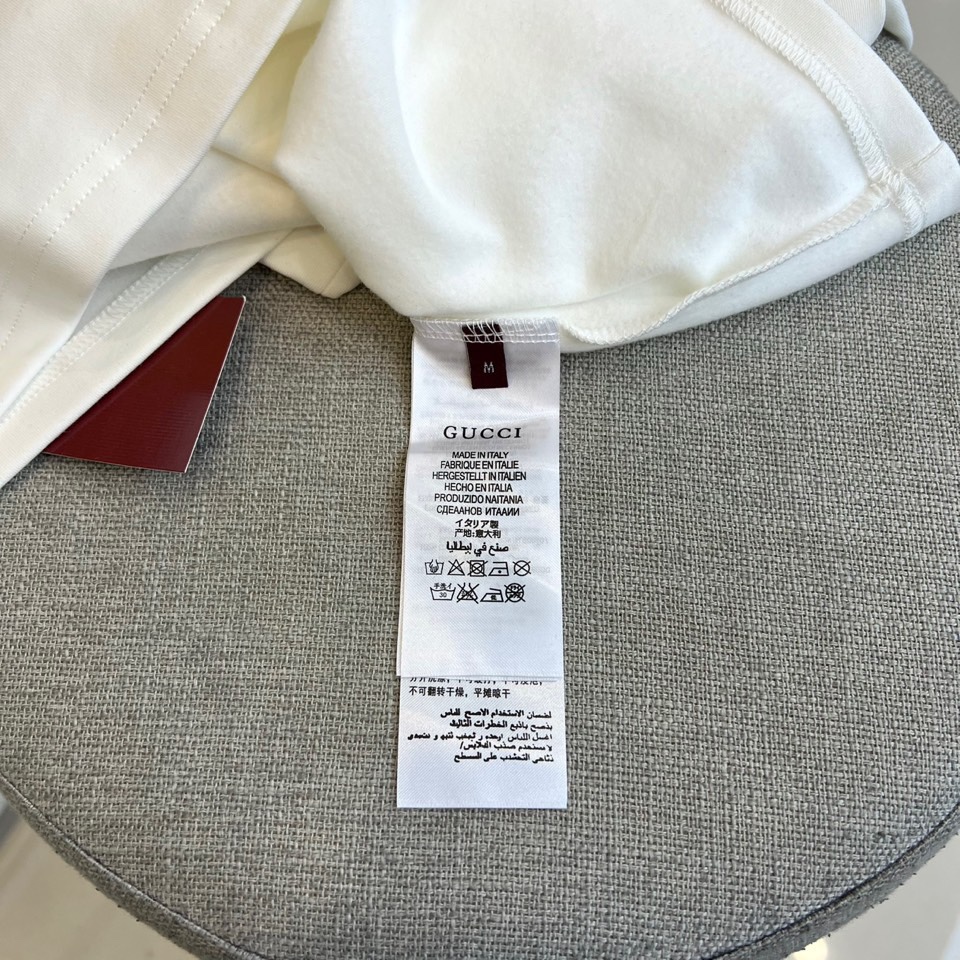 Gucc古驰、2025秋冬新品男士白色长袖上衣，以纯净白色诠释意式奢华美学。衣领处饰有黑色“GUCCI”