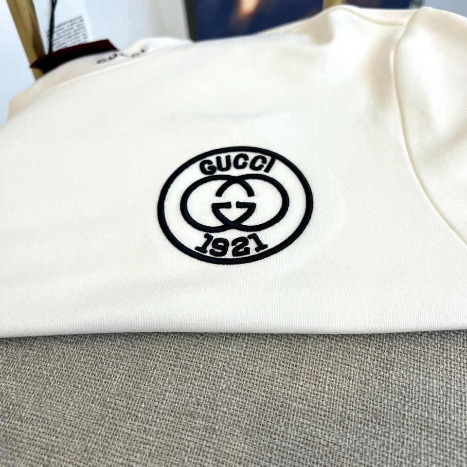 Gucc古驰、2025秋冬新品男士白色长袖上衣，以纯净白色诠释意式奢华美学。衣领处饰有黑色“GUCCI”