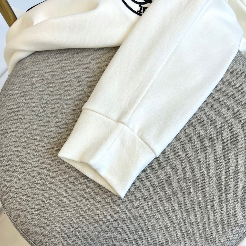 Gucc古驰、2025秋冬新品男士白色长袖上衣，以纯净白色诠释意式奢华美学。衣领处饰有黑色“GUCCI”