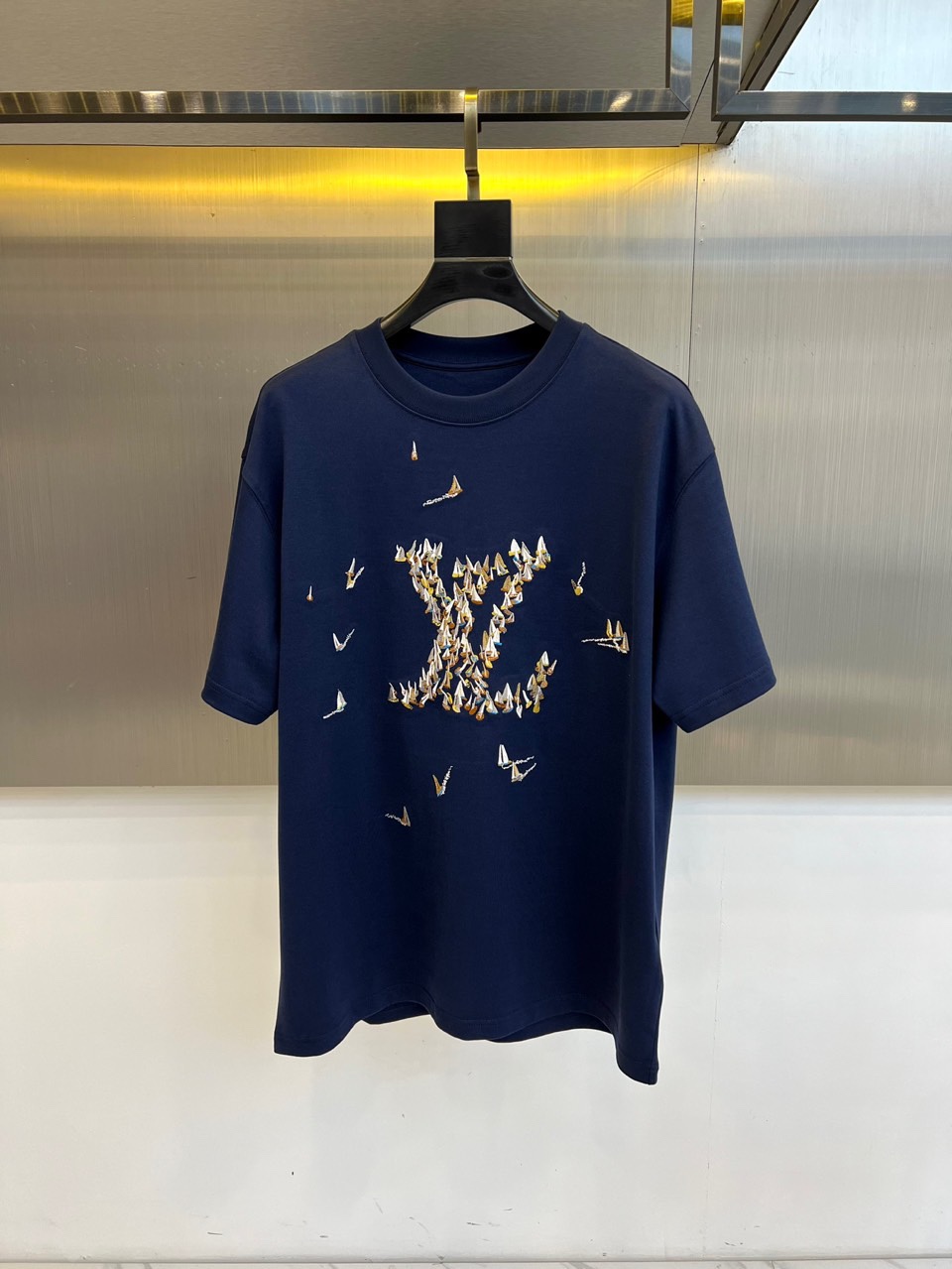 1v威登、2025秋冬新品蝴蝶元素短袖T恤。这款白色短袖T恤以品牌经典标志为设计核心，创新采用蝴蝶图案组