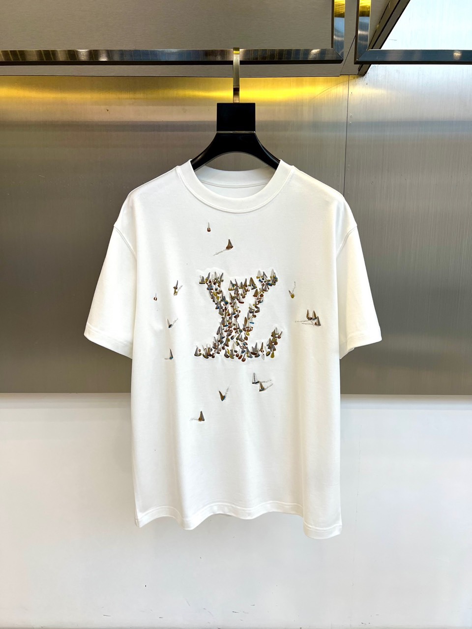 1v威登、2025秋冬新品蝴蝶元素短袖T恤。这款白色短袖T恤以品牌经典标志为设计核心，创新采用蝴蝶图案组