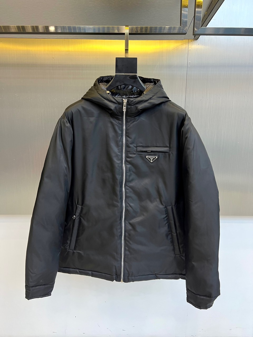 Prad普拉达、2025秋冬新款羽绒服，这款连帽羽绒服采用立体菱形绗缝工艺，勾勒出饱满的几何轮廓，既确保