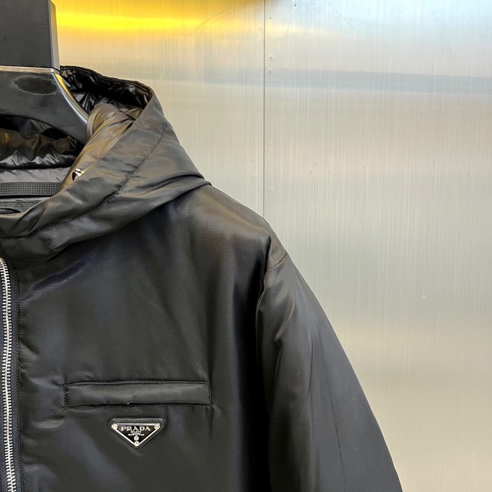 Prad普拉达、2025秋冬新款羽绒服，这款连帽羽绒服采用立体菱形绗缝工艺，勾勒出饱满的几何轮廓，既确保