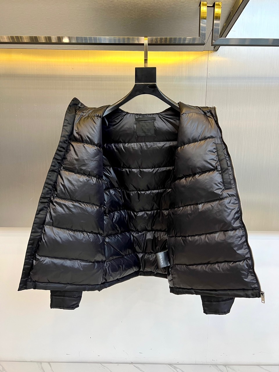 Prad普拉达、2025秋冬新款羽绒服，这款连帽羽绒服采用立体菱形绗缝工艺，勾勒出饱满的几何轮廓，既确保