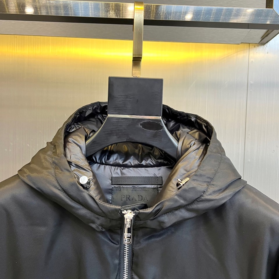 Prad普拉达、2025秋冬新款羽绒服，这款连帽羽绒服采用立体菱形绗缝工艺，勾勒出饱满的几何轮廓，既确保