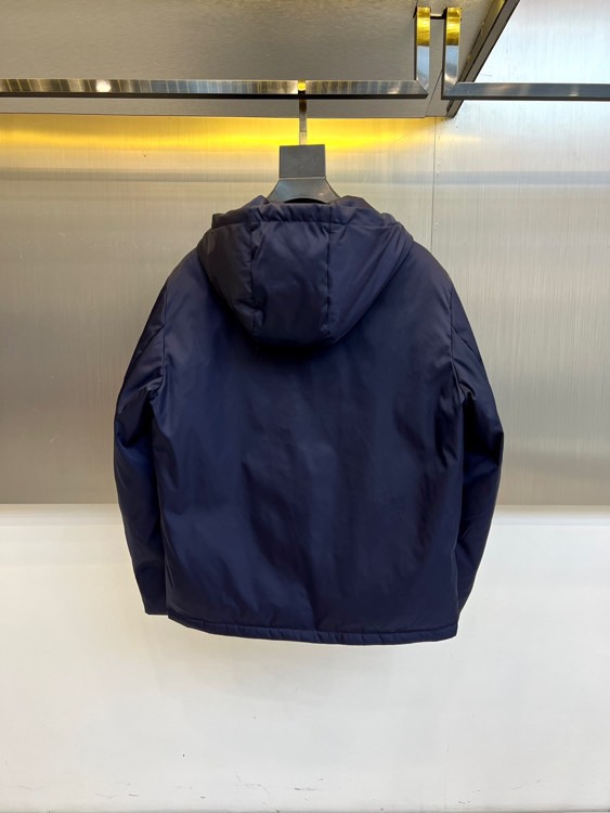 Prad普拉、2025秋冬新品 PRADA科技防护羽绒服。深蓝色连帽设计搭配精密拉链系统，左胸红色织带镶