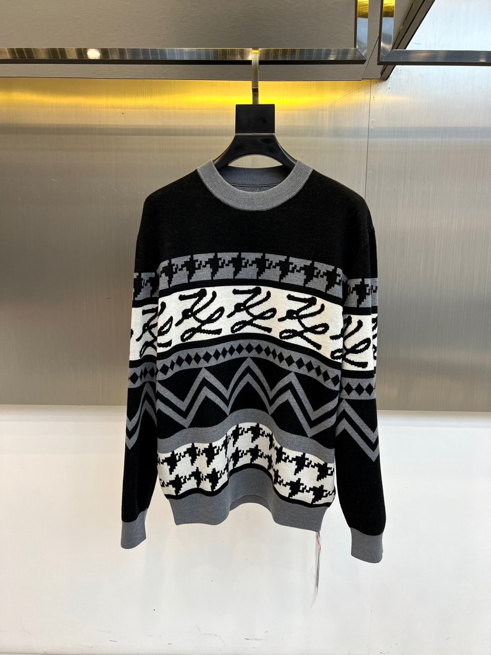 Fend芬迪、2025秋冬新品 | FENDI复古学院风羊毛毛衣。这款黑色圆领毛衣以千鸟格纹为基底，衣身