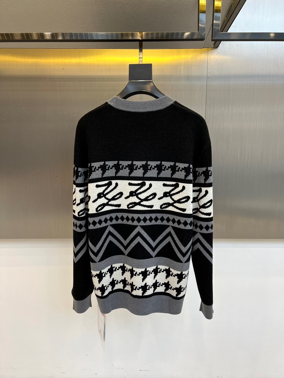 Fend芬迪、2025秋冬新品 | FENDI复古学院风羊毛毛衣。这款黑色圆领毛衣以千鸟格纹为基底，衣身