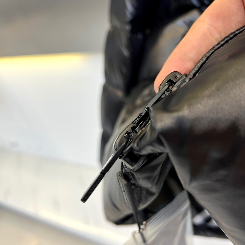 Bur巴宝莉、2025秋冬新品格纹羽绒服，以经典黑色演绎英伦户外美学。款式采用连帽设计搭配可调节抽绳系统