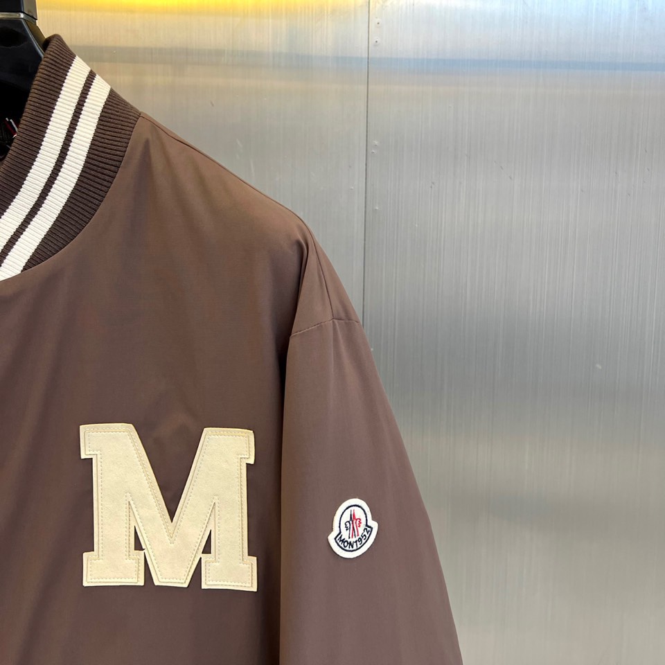 Mon蒙口、2025秋冬新品 蒙口经典运动夹克。这款藏青色夹克以棒球服廓形演绎现代运动美学，罗纹立领与袖