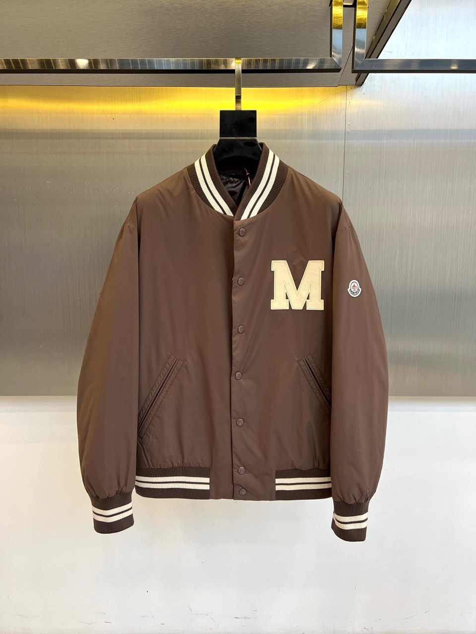 Mon蒙口、2025秋冬新品 蒙口经典运动夹克。这款藏青色夹克以棒球服廓形演绎现代运动美学，罗纹立领与袖