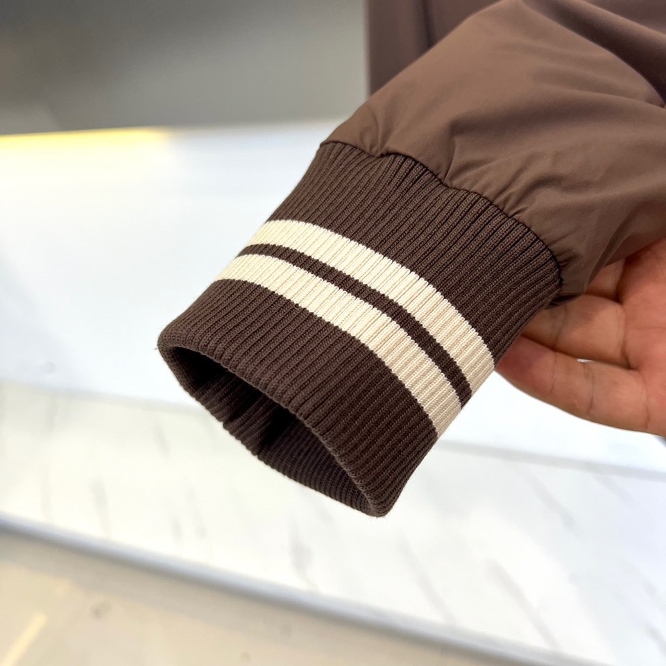 Mon蒙口、2025秋冬新品 蒙口经典运动夹克。这款藏青色夹克以棒球服廓形演绎现代运动美学，罗纹立领与袖