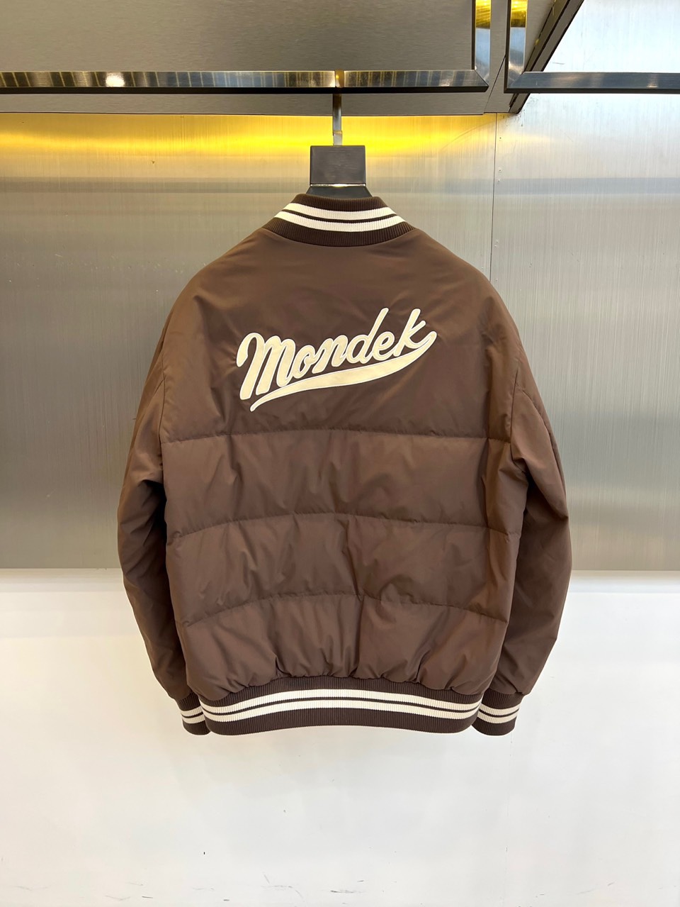 Mon蒙口、2025秋冬新品 蒙口经典运动夹克。这款藏青色夹克以棒球服廓形演绎现代运动美学，罗纹立领与袖