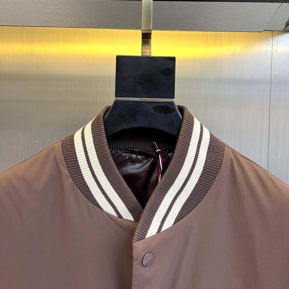 Mon蒙口、2025秋冬新品 蒙口经典运动夹克。这款藏青色夹克以棒球服廓形演绎现代运动美学，罗纹立领与袖