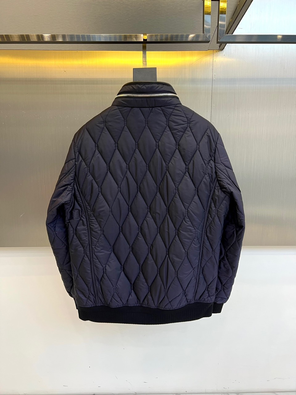 Bur巴宝莉、2025秋冬新品棉服，将经典格纹与都市机能精妙融合。此款采用深邃的藏蓝色调，通身以精细的菱