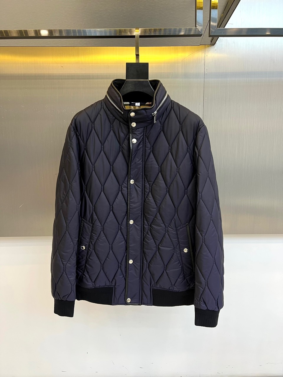 Bur巴宝莉、2025秋冬新品棉服，将经典格纹与都市机能精妙融合。此款采用深邃的藏蓝色调，通身以精细的菱