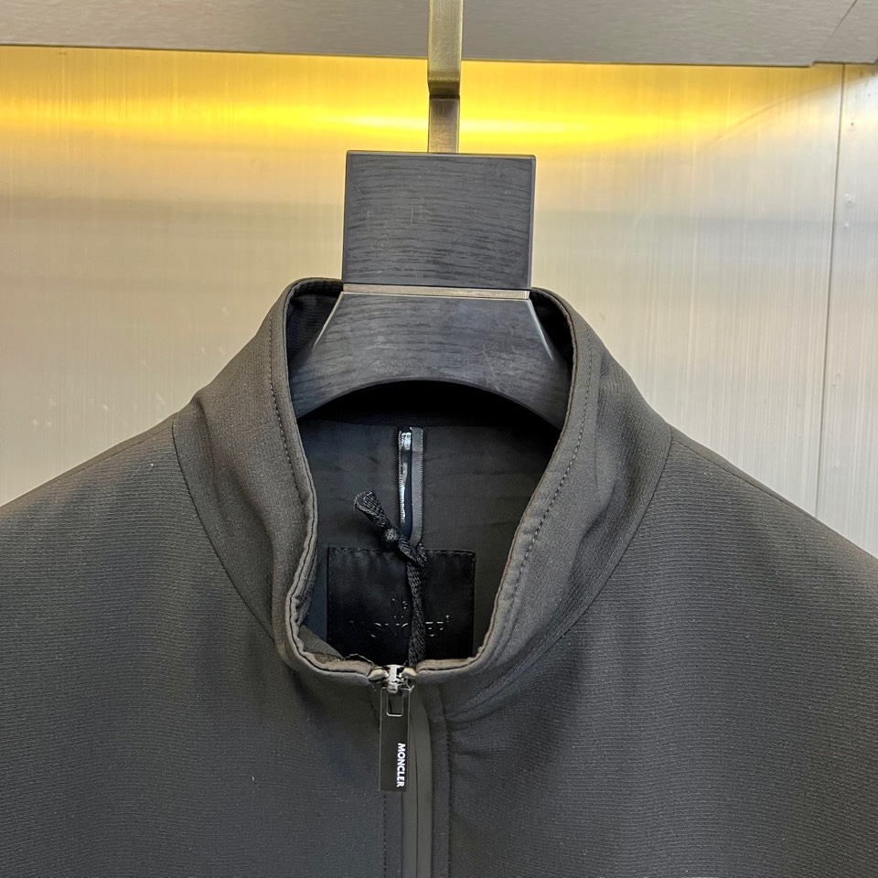 Mon蒙口、2025秋冬新品男士夹克，以简约轮廓重塑日常优雅。本品采用经典黑色面料，立领设计赋予颈部利落