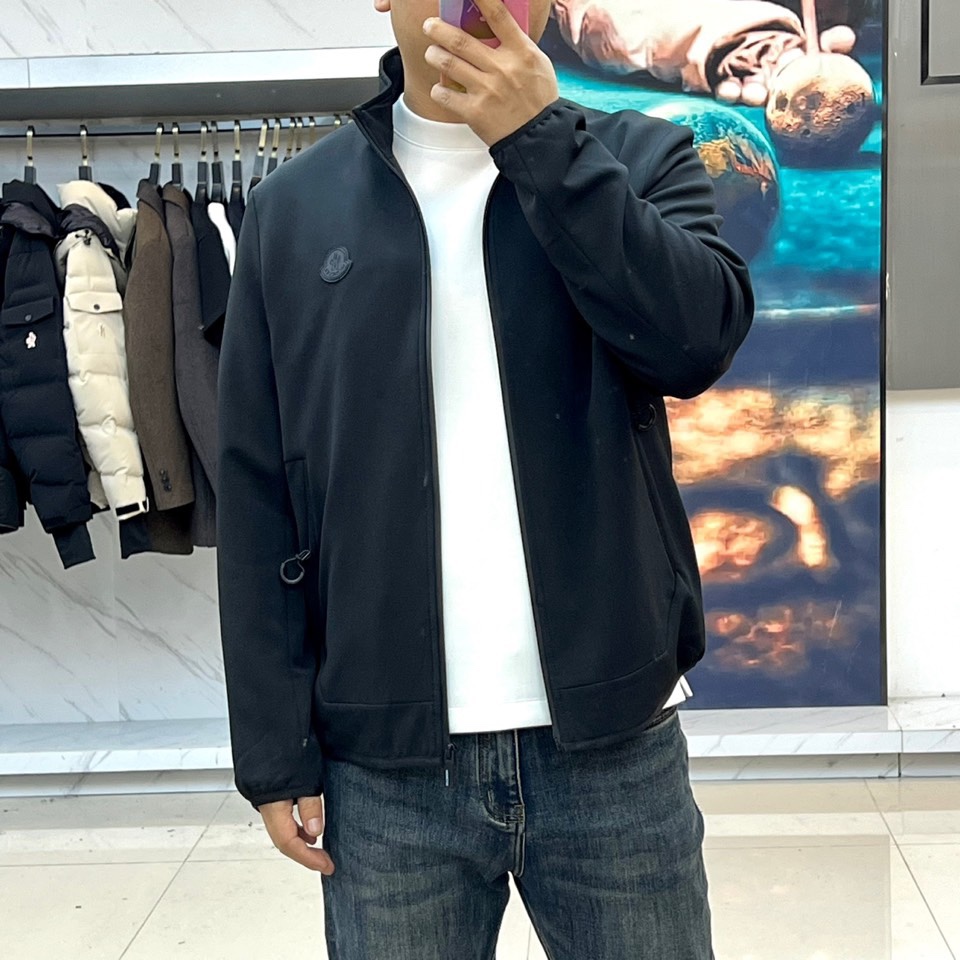 Mon蒙口、2025秋冬新品男士夹克，以简约轮廓重塑日常优雅。本品采用经典黑色面料，立领设计赋予颈部利落