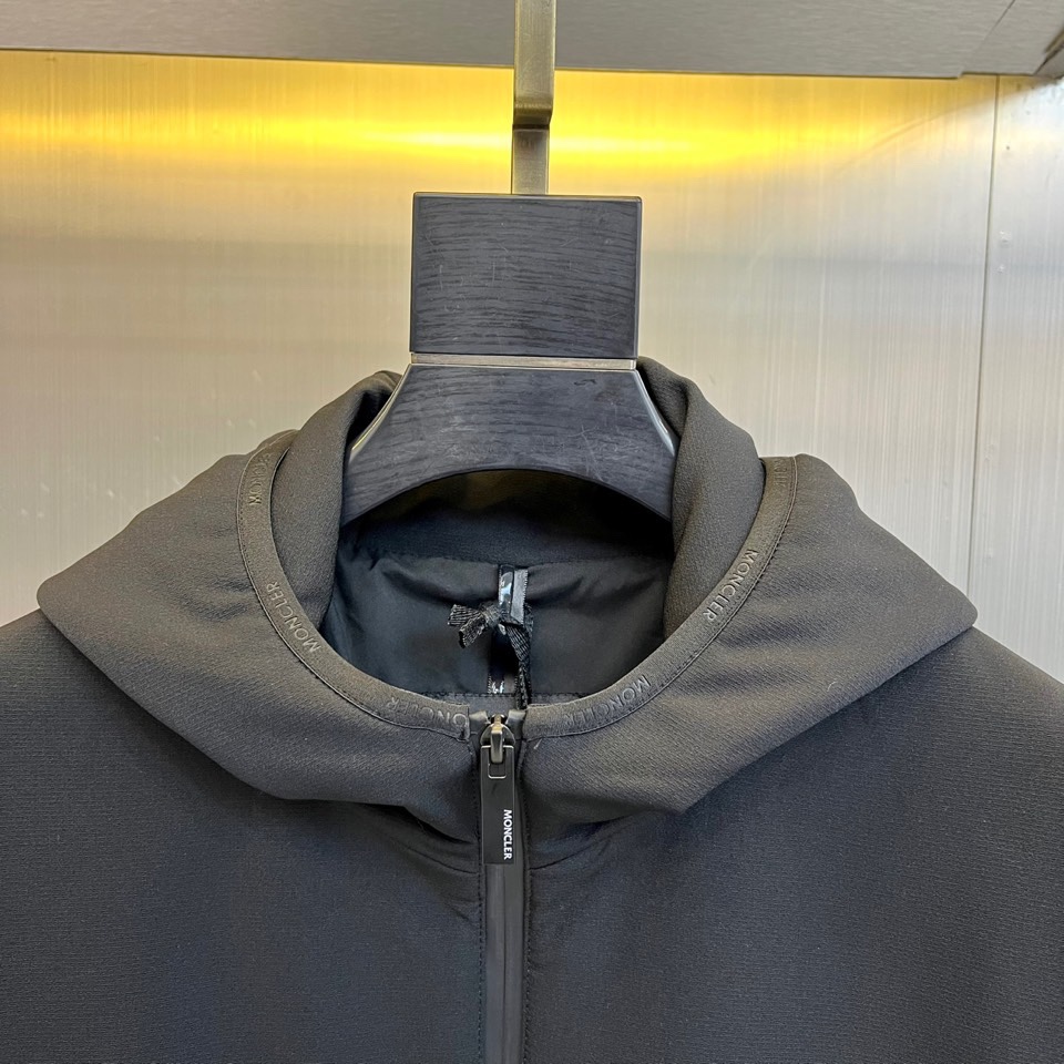 Mon蒙口、2025秋冬新款男士连帽外套，以极简设计诠释现代日常美学。本品采用质感出色的黑色面料，剪裁利