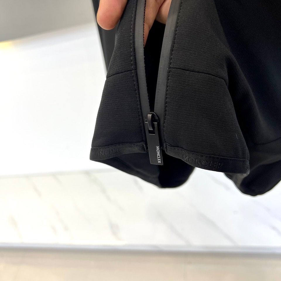 Mon蒙口、2025秋冬新款男士连帽外套，以极简设计诠释现代日常美学。本品采用质感出色的黑色面料，剪裁利