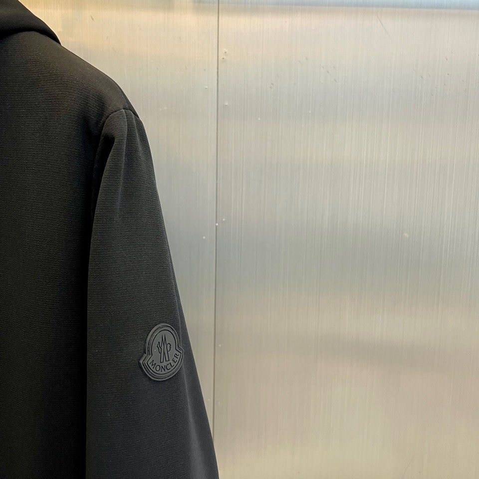 Mon蒙口、2025秋冬新款男士连帽外套，以极简设计诠释现代日常美学。本品采用质感出色的黑色面料，剪裁利