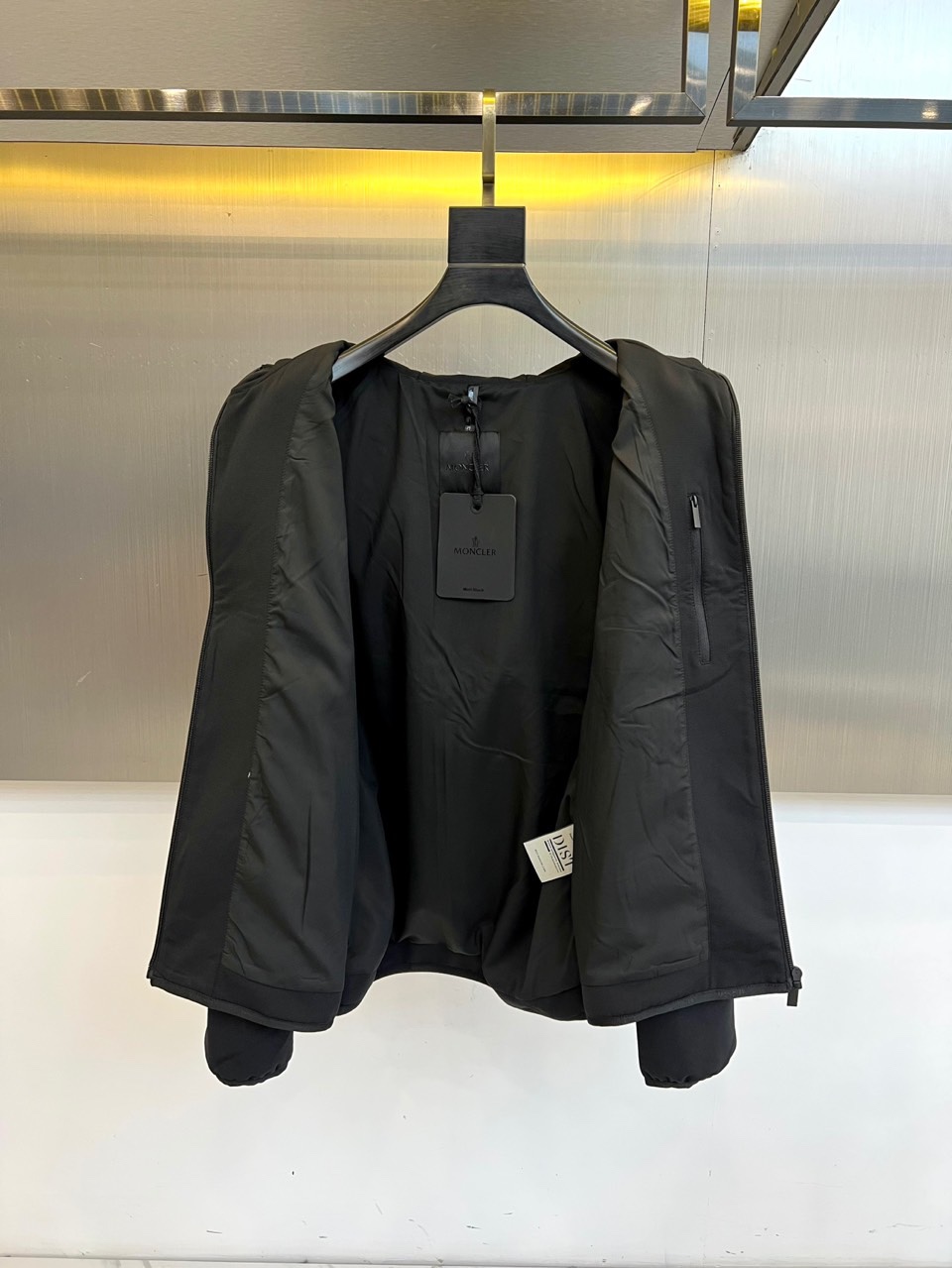 Mon蒙口、2025秋冬新款男士连帽外套，以极简设计诠释现代日常美学。本品采用质感出色的黑色面料，剪裁利