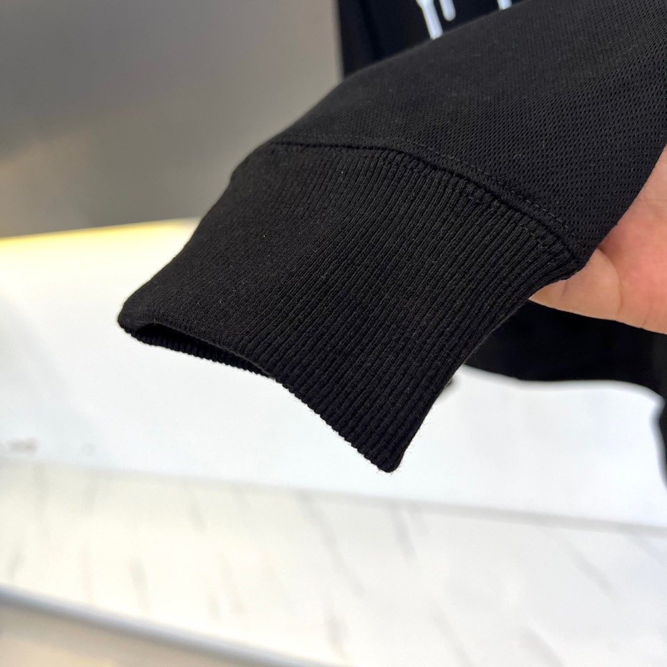 Mon蒙口、2025秋冬新品加绒连帽卫衣，款式采用经典连帽与宽松版型，胸前饰以醒目的黑色泼墨涂鸦“MON