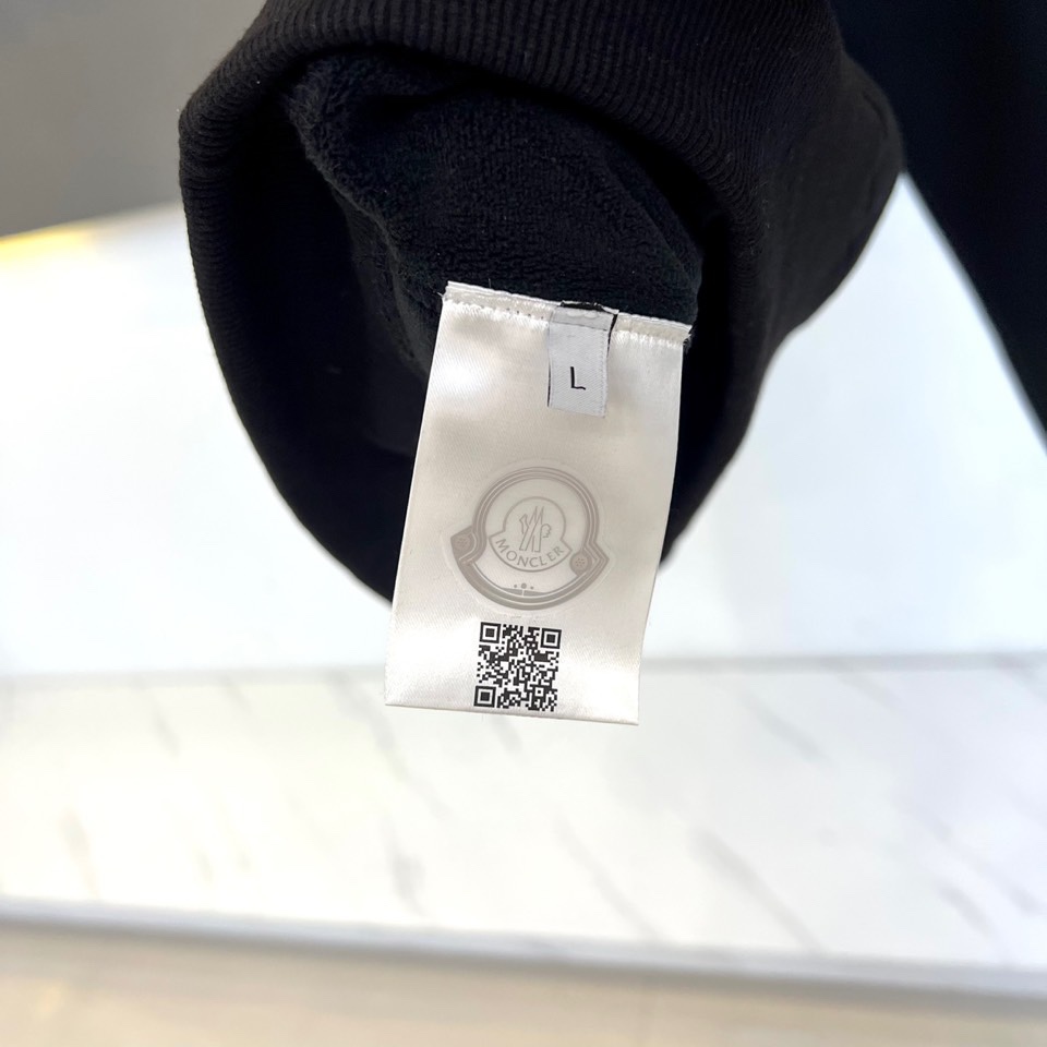 Mon蒙口、2025秋冬新品加绒连帽卫衣，款式采用经典连帽与宽松版型，胸前饰以醒目的黑色泼墨涂鸦“MON