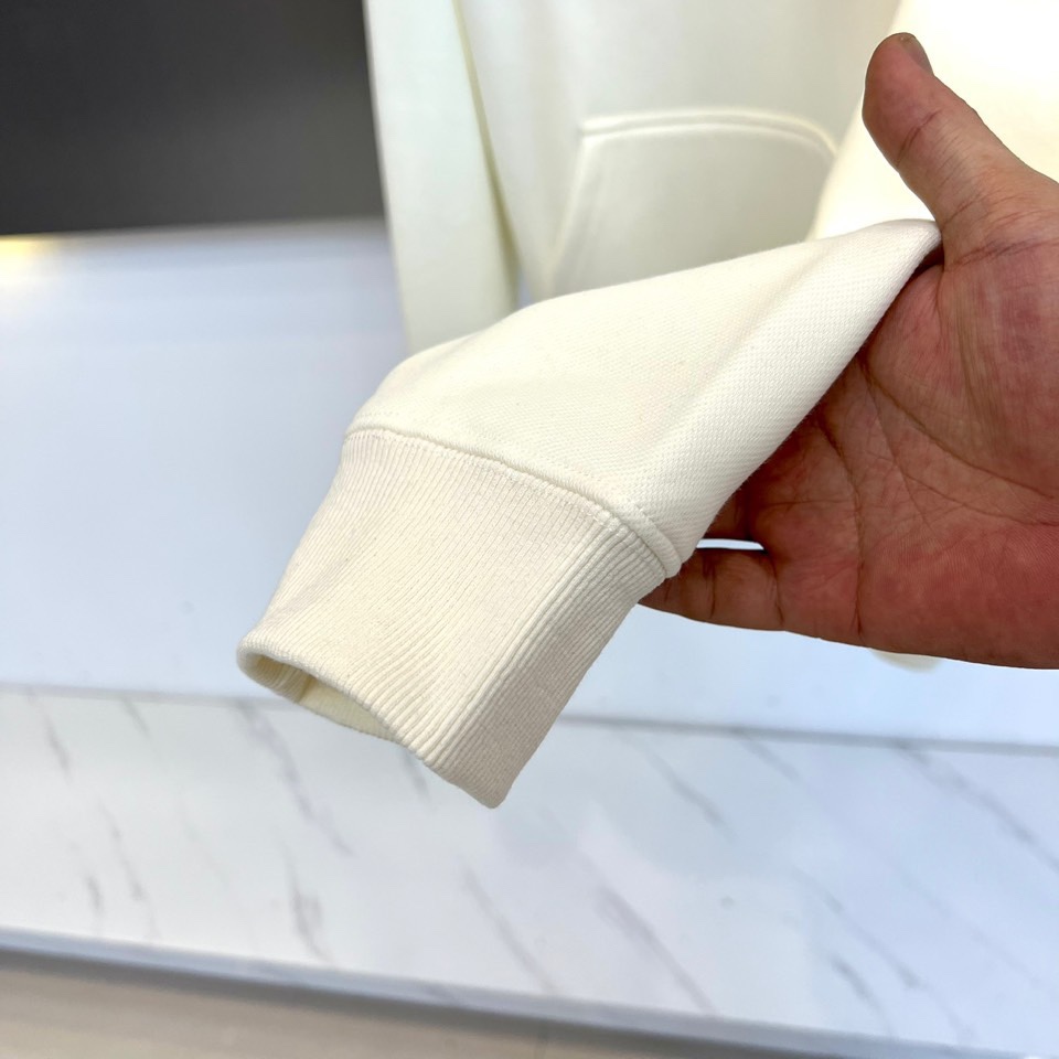 Mon蒙口、2025秋冬新品加绒连帽卫衣，款式采用经典连帽与宽松版型，胸前饰以醒目的黑色泼墨涂鸦“MON