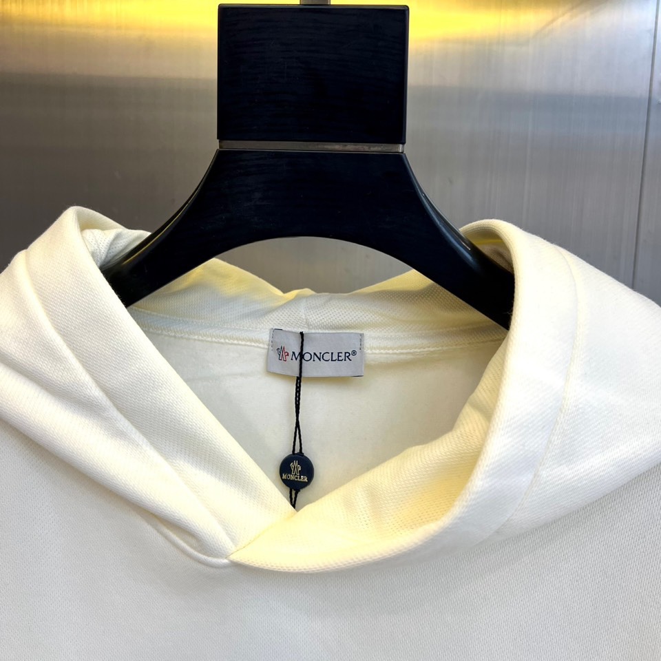 Mon蒙口、2025秋冬新品加绒连帽卫衣，款式采用经典连帽与宽松版型，胸前饰以醒目的黑色泼墨涂鸦“MON