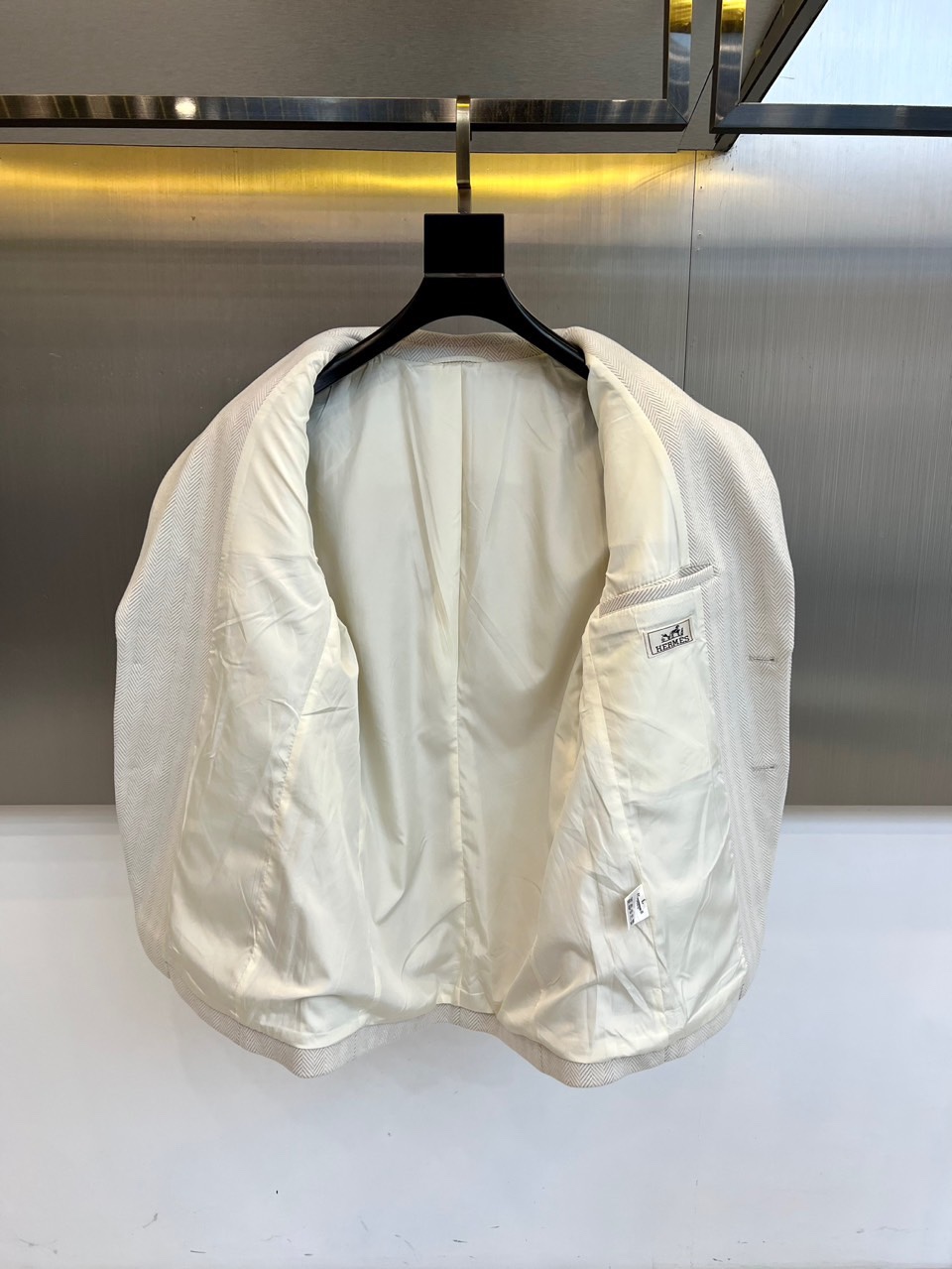 H爱马仕、2025秋冬新品羊毛西服，以温润米白色演绎永恒优雅。这款西服采用精纺羊毛材质织就细腻人字纹肌理