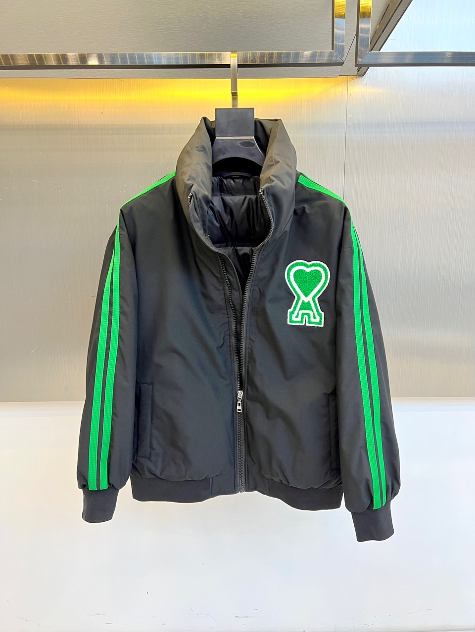 Ami 2025秋冬新品羽绒服，以简约立领设计融合运动美学，重新定义都市冬日时尚。款式采用利落的拉链开合