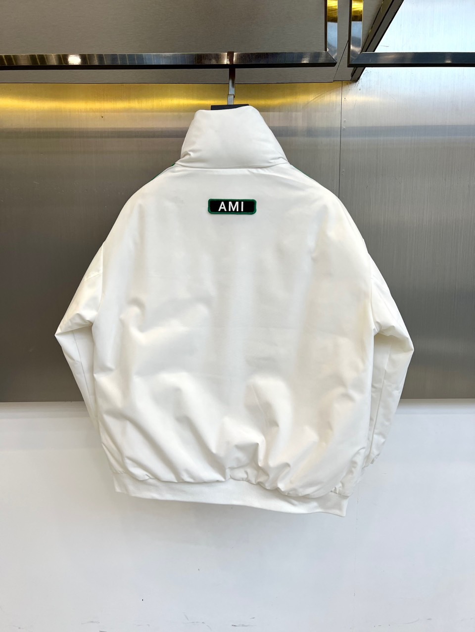 Ami 2025秋冬新品羽绒服，以简约立领设计融合运动美学，重新定义都市冬日时尚。款式采用利落的拉链开合