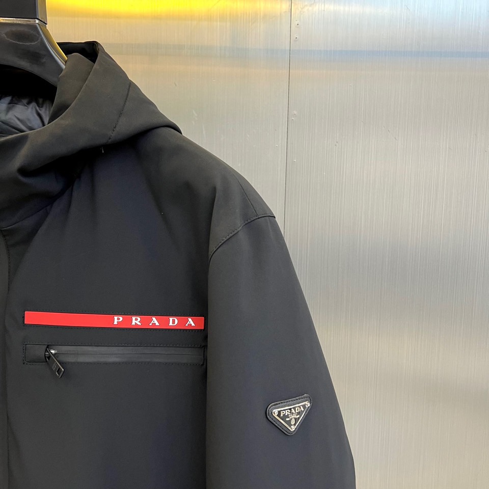Prad普拉（鹅绒）、2025秋冬新品鹅绒中长款羽绒服，以经典黑色演绎永恒奢华。中长版型兼顾保暖与风度，