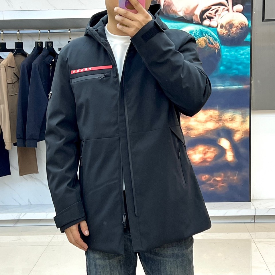 Prad普拉（鹅绒）、2025秋冬新品鹅绒中长款羽绒服，以经典黑色演绎永恒奢华。中长版型兼顾保暖与风度，