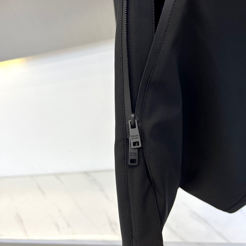 Prad普拉（鹅绒）、2025秋冬新品鹅绒中长款羽绒服，以经典黑色演绎永恒奢华。中长版型兼顾保暖与风度，