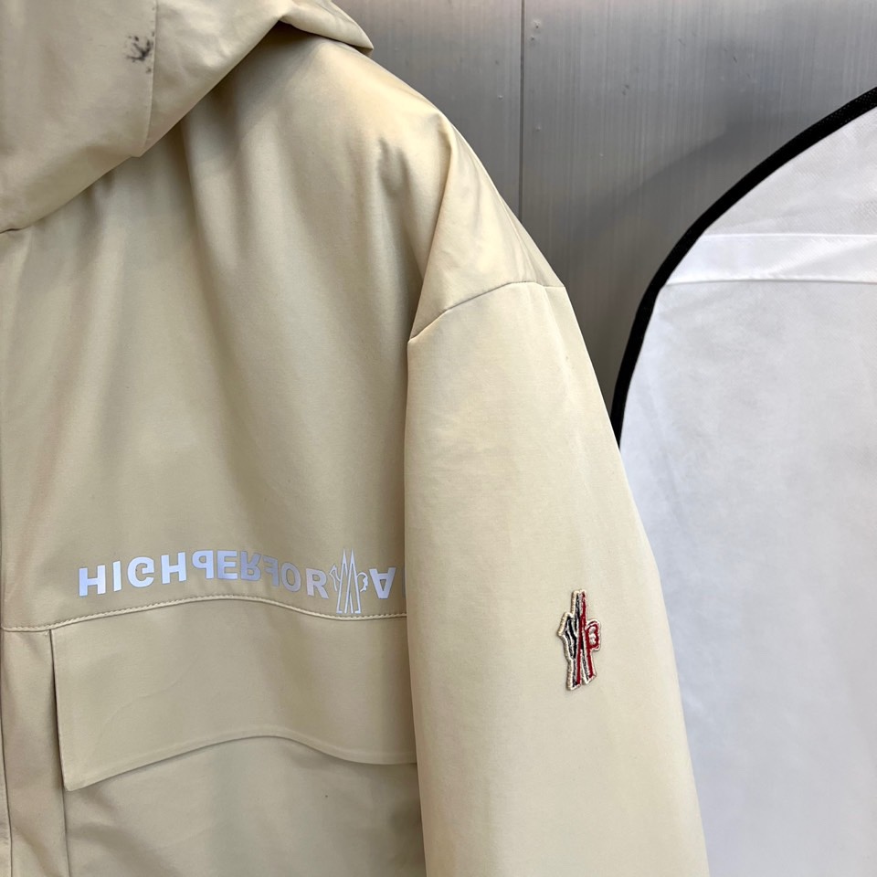 MON蒙口（高端白鹅绒）、2025秋冬新品男士高性能滑雪羽绒服，以米白色调演绎极简机能美学。连帽设计搭配