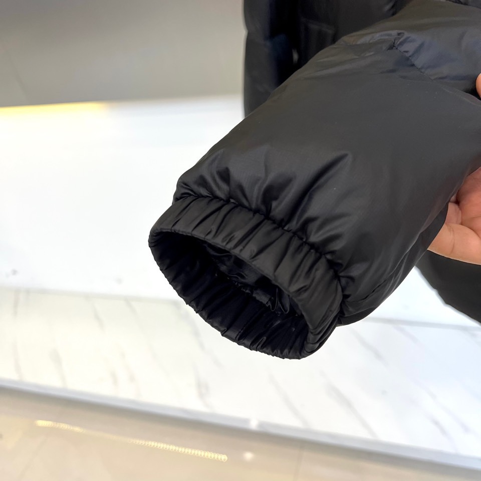 Mon蒙口（白鹅绒）、2025秋冬新款短款羽绒服以极简设计演绎现代冬日美学。连帽设计搭配可调节抽绳，兼顾