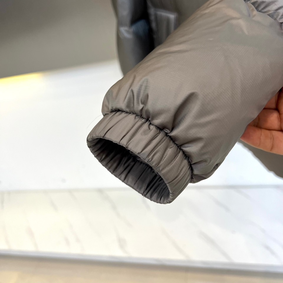 Mon蒙口（白鹅绒）、2025秋冬新款短款羽绒服以极简设计演绎现代冬日美学。连帽设计搭配可调节抽绳，兼顾