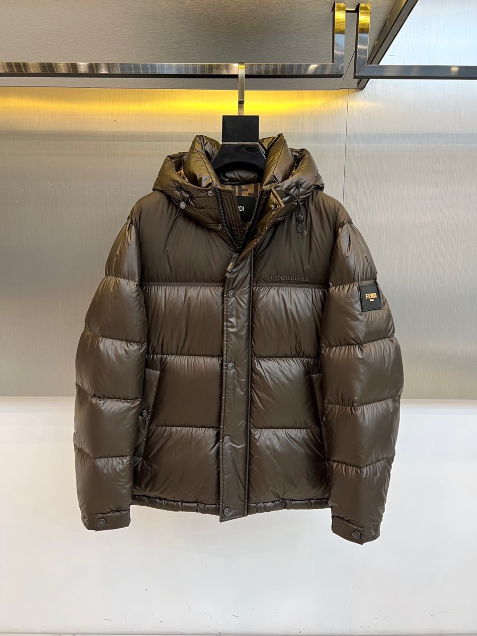 Fend芬迪（鹅绒）、2025秋冬新品羽绒服以纯黑配色诠释奢华运动美学。这款连帽羽绒服采用宽松廓形设计，